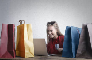 A girl with laptop and bags illustrating online shopping